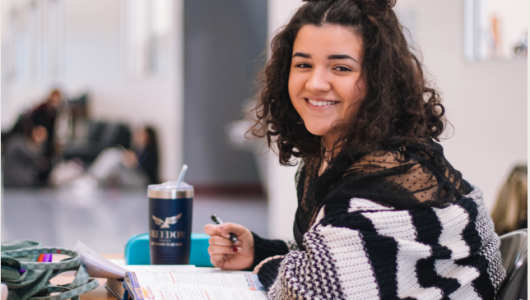 Student smiling while writing