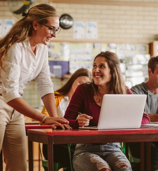 Woman high school professor helping student in class