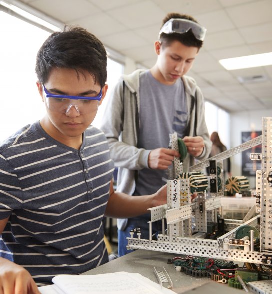 Two Male College Students Building Machine In Science Robotics Or Engineering Class