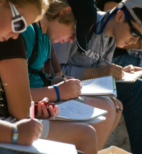 Students writing while outside