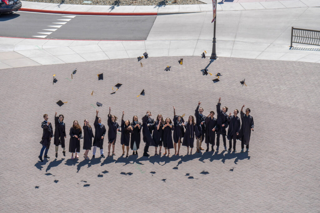 Davidson Academy graduates throwing their graduation caps in the air