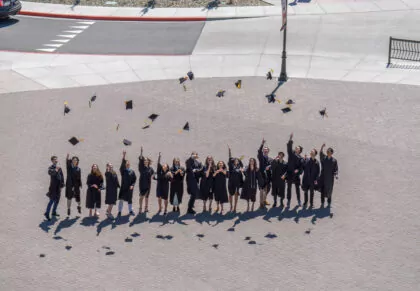 Davidson Academy graduates throwing their graduation caps in the air