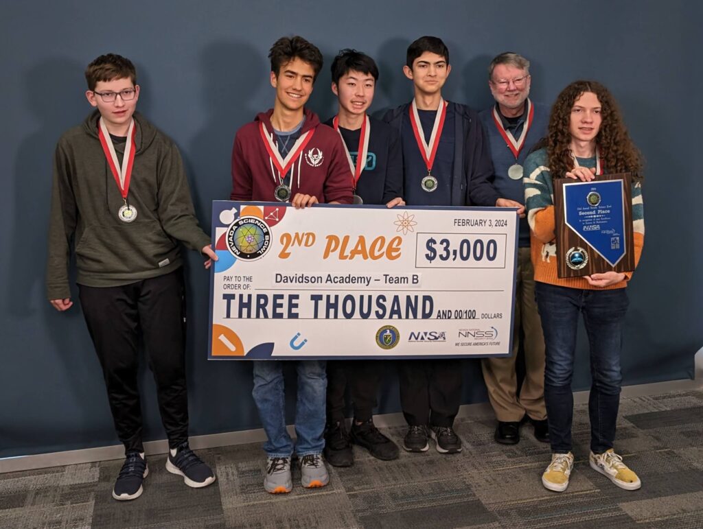 Team B holding up their second place plaque and a $3,000 check