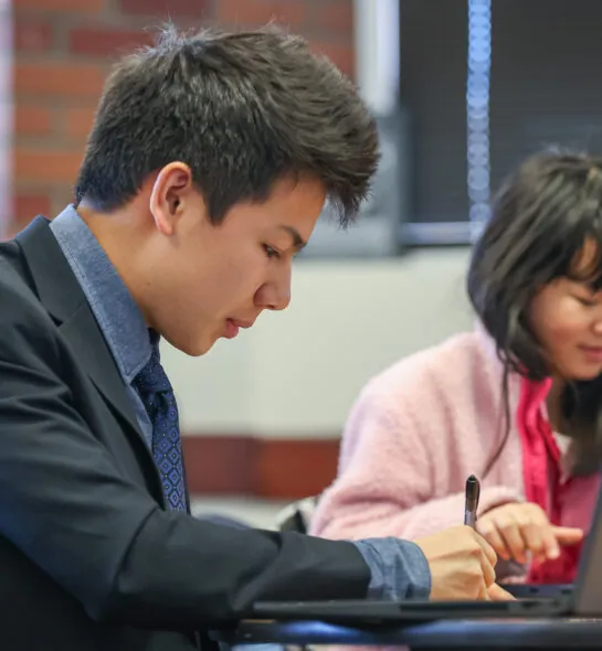 Student dressed formally working on laptop