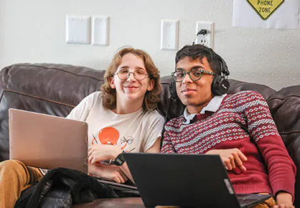 Students smiling on a couch