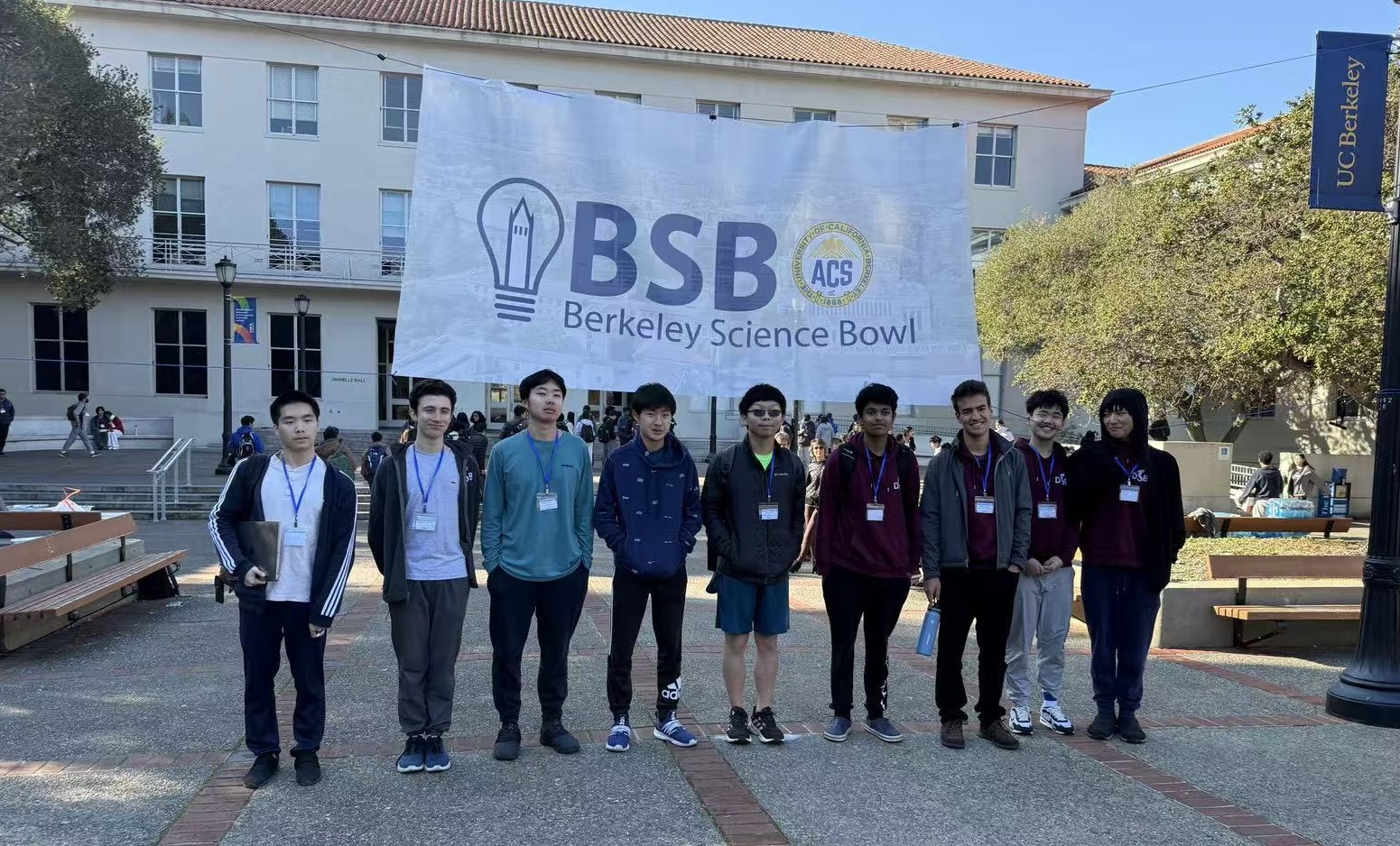 Students posing for a photo in front of campus building
